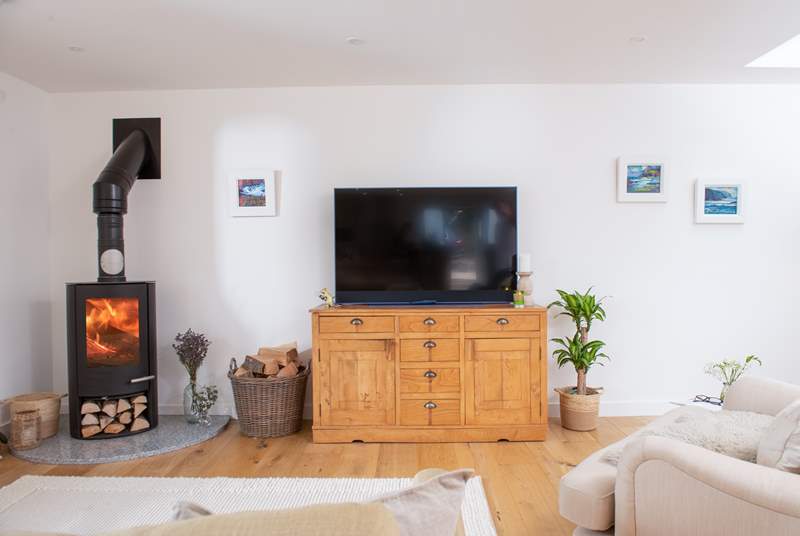 The homely sitting area comes complete with a Smart TV and a toasty wood-burner.