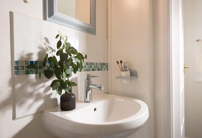 The bathroom is wonderfully finished with lovely tiles and greenery.