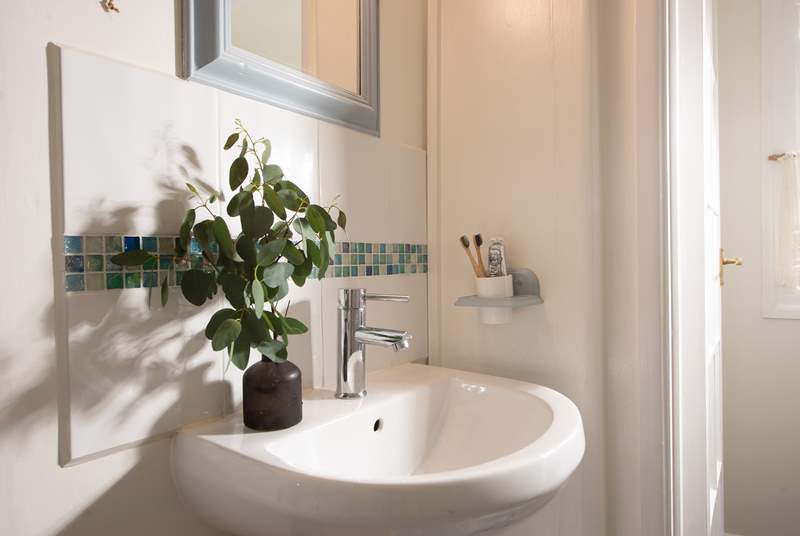 The bathroom is wonderfully finished with lovely tiles and greenery.