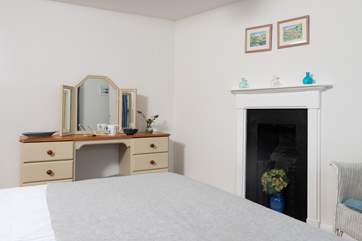 A charming ornamental fireplace is tucked into the corner of the room.
