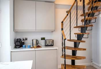 A steep spiral staircase leads up to the first floor bedroom.