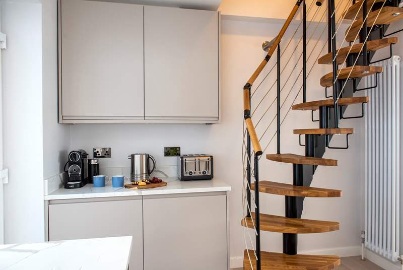 A steep spiral staircase leads up to the first floor bedroom.