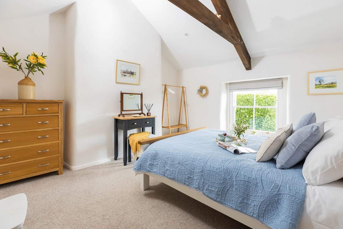 The dreamy double bedroom has pretty linens and characterful beams.