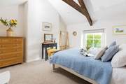 The dreamy double bedroom has pretty linens and characterful beams.