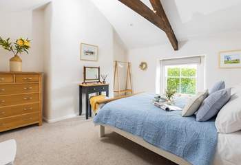 The dreamy double bedroom has pretty linens and characterful beams.