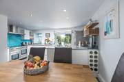 The light and airy kitchen/diner with doors out onto the raised decking area, to the back of the house.