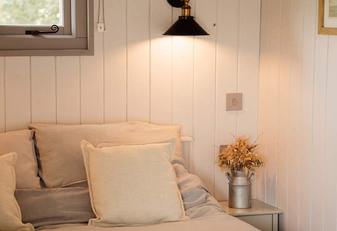 The inviting double bed promises restful nights beneath soft linens.