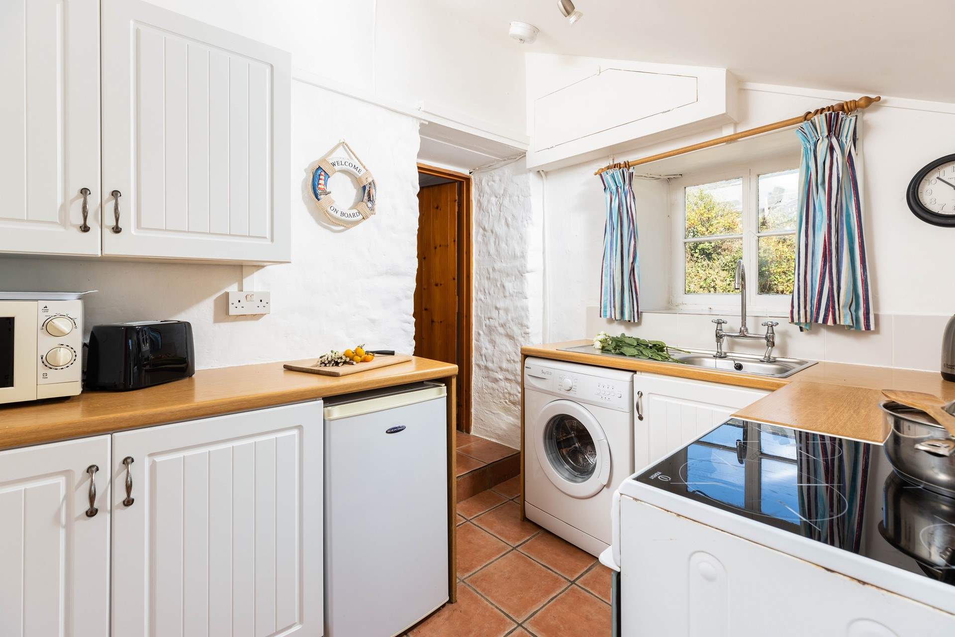 The kitchen leads through to the sitting/dining-room, please watch your head on the steps and low beam in this old cottage. 