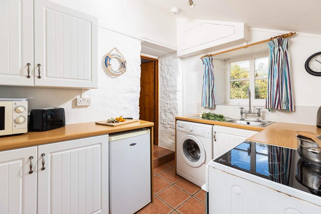 The kitchen leads through to the sitting/dining-room, please watch your head on the steps and low beam in this old cottage.
