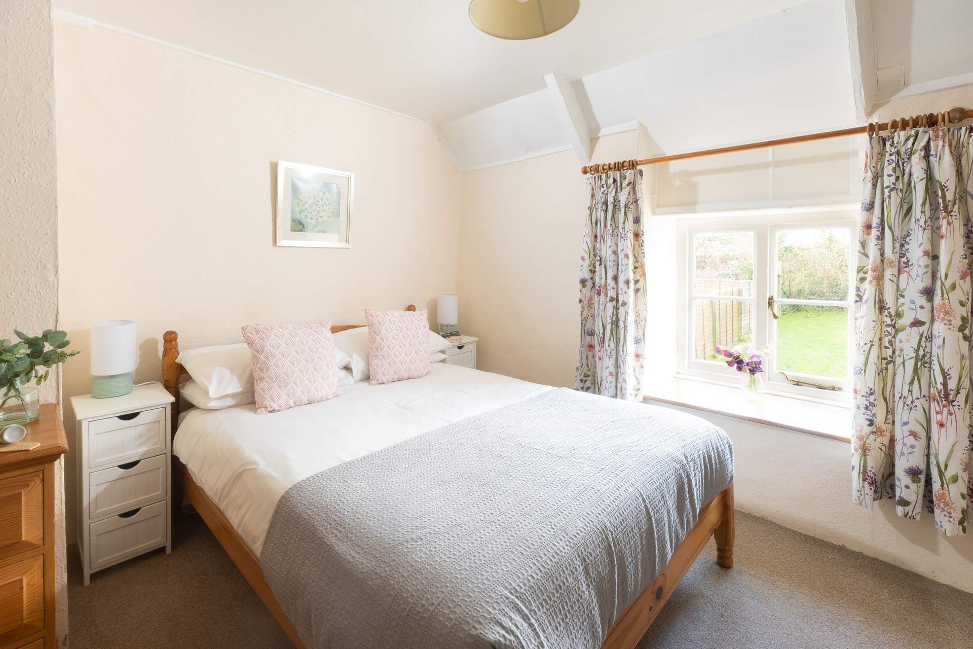 This pretty bedroom overlooks the sunny garden. 