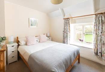 This pretty bedroom overlooks the sunny garden. 