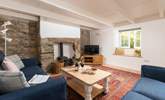 The sitting-room has original exposed stonework and characterful beams. - Thumbnail Image