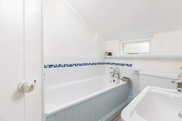 The bathroom on the ground floor has a bath with hand-held shower, and a separate shower cubicle.