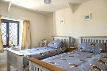 The second bedroom has twin beds adorned with playful linens