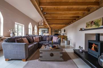 The stylish sitting/dining-room has a warming wood-burner effect gas stove.
