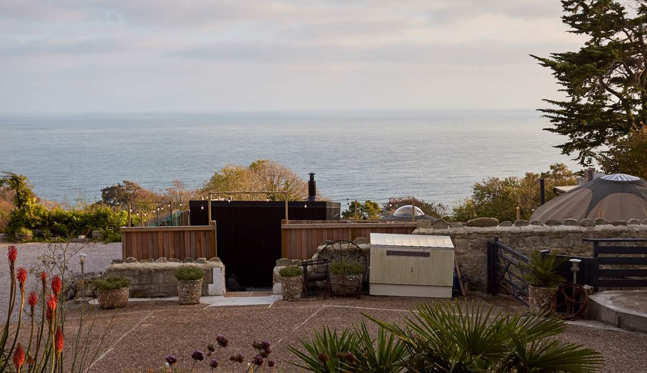 The outdoor spa enjoys stunning views over a blue horizon.