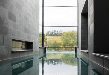 Gorgeous slate tiles and a stunning multi-storey window enclose the fabulous swimming pool.