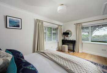 Spacious bedroom 1 with garden views, a king-size bed and en suite bathroom.