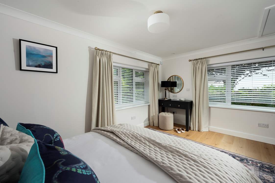 Spacious bedroom 1 with garden views, a king-size bed and en suite bathroom.