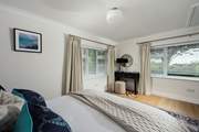 Spacious bedroom 1 with garden views, a king-size bed and en suite bathroom.