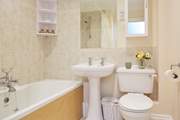 The family bathroom has a bath with shower over.