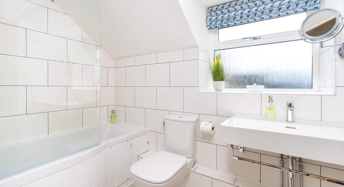 The stylish family bathroom has a bath with fitted shower.