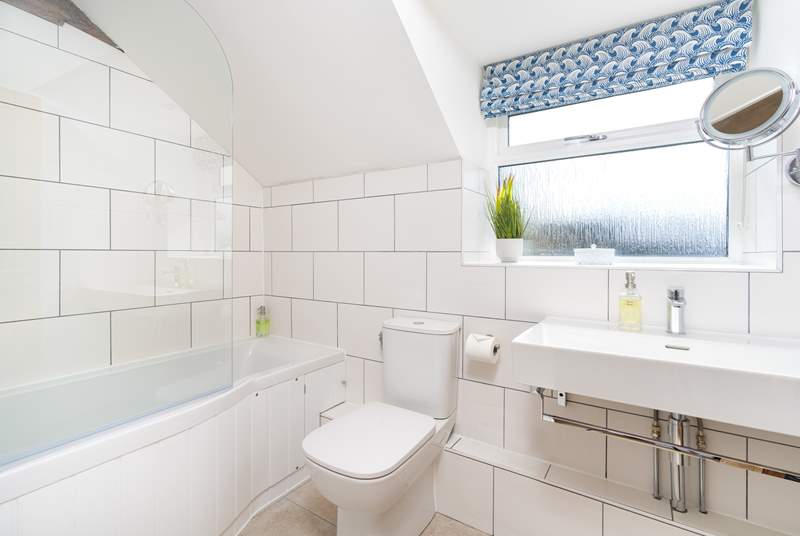 The stylish family bathroom has a bath with fitted shower.