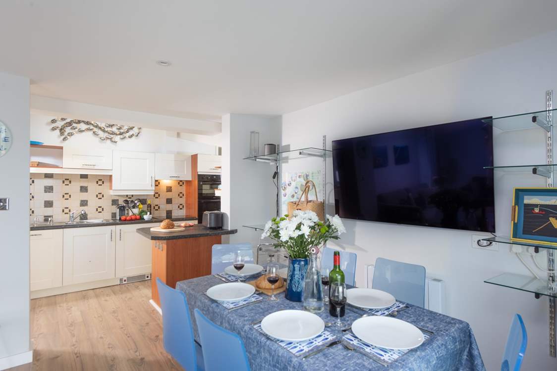 The kitchen is perfectly placed next to the dining-table.