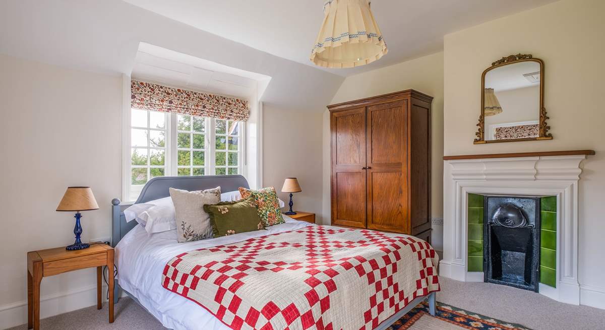 This bedroom also has a lovely ornamental fireplace.