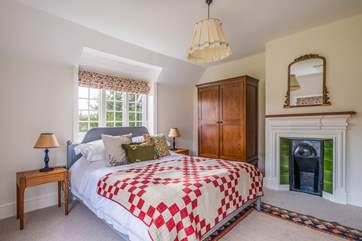 This bedroom also has a lovely ornamental fireplace.