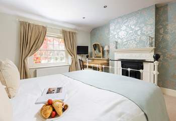 Gorgeous bedroom 2 has an ornamental fireplace.