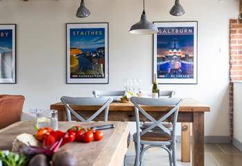The dining area, with its reclaimed dining-table, is situated next to the kitchen.
