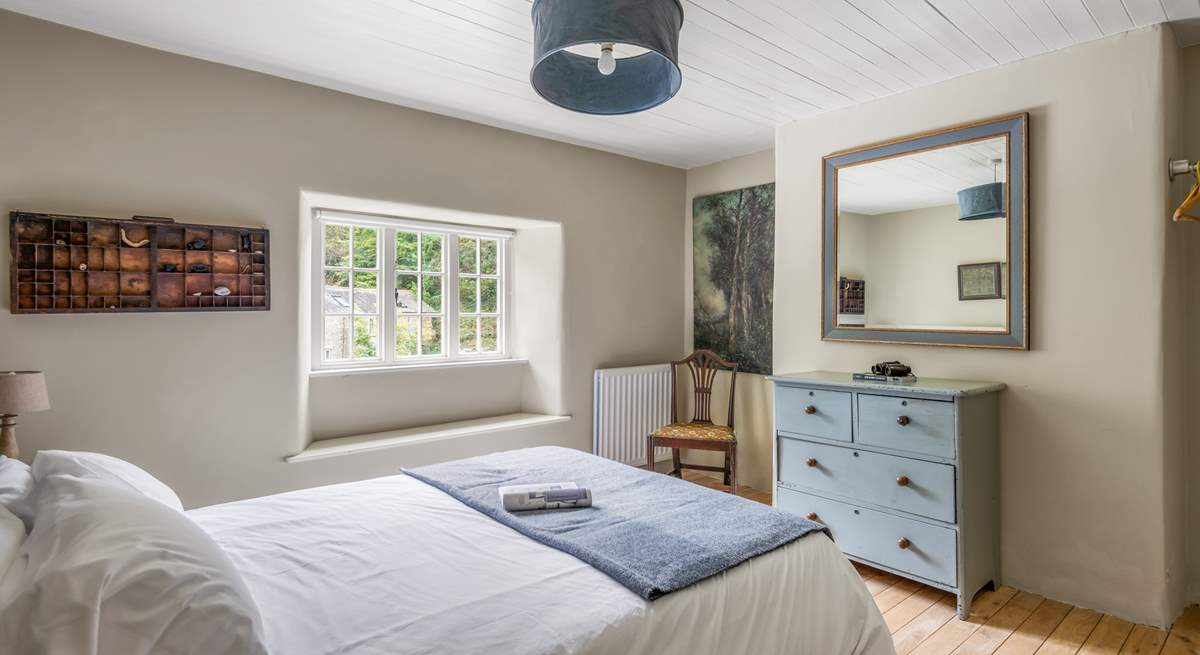 Bedroom 2 with a king-size bed is beautifully furnished in soft pastel shades.