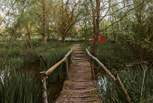 Wander across the bridge to your secluded wood-fired hot tub... 