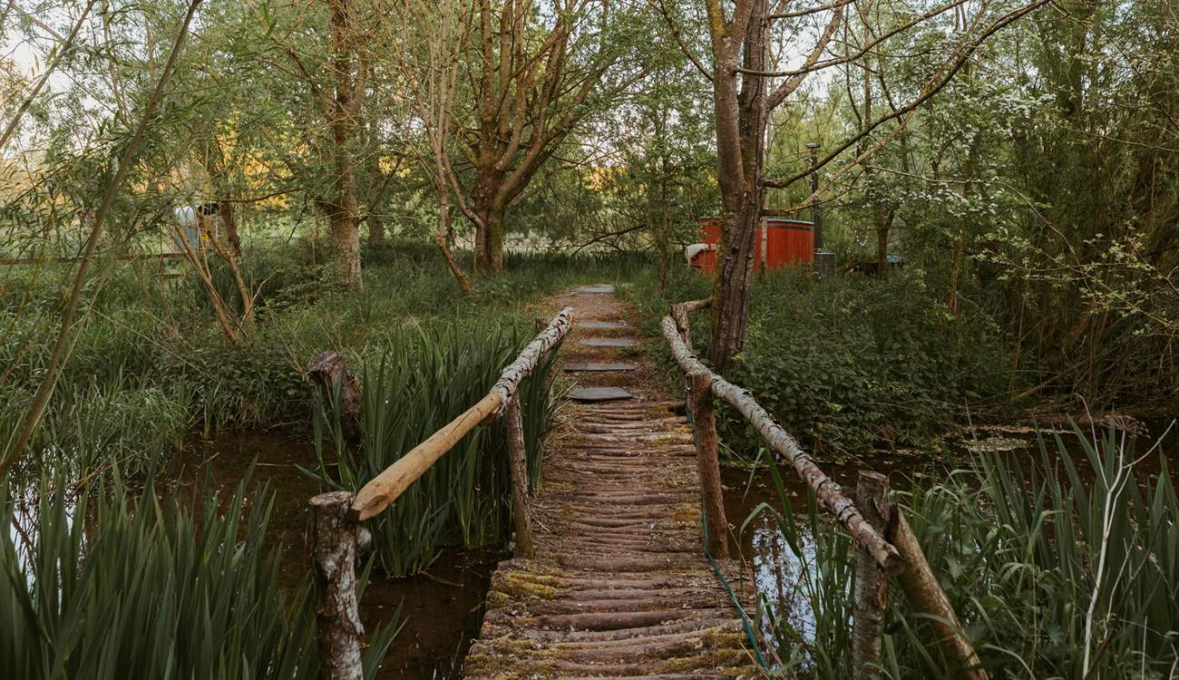 Wander across the bridge to your secluded wood-fired hot tub... 