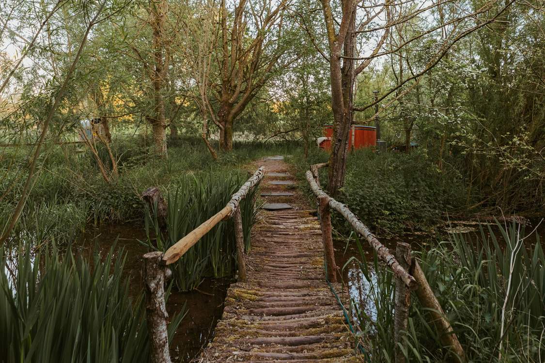 Wander across the bridge to your secluded wood-fired hot tub...