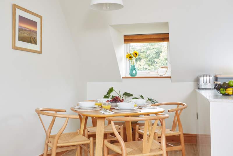 A wonderfully intimate wooden dining-table sits in the corner of the space.