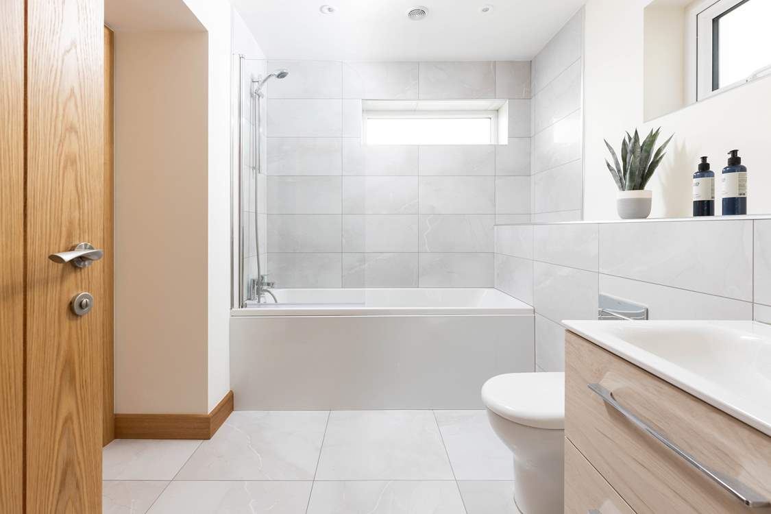 This stylish en suite has a bath with shower over.