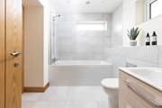 This stylish en suite has a bath with shower over.