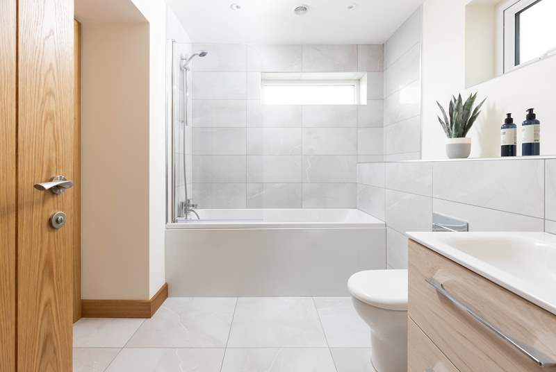 This stylish en suite has a bath with shower over.