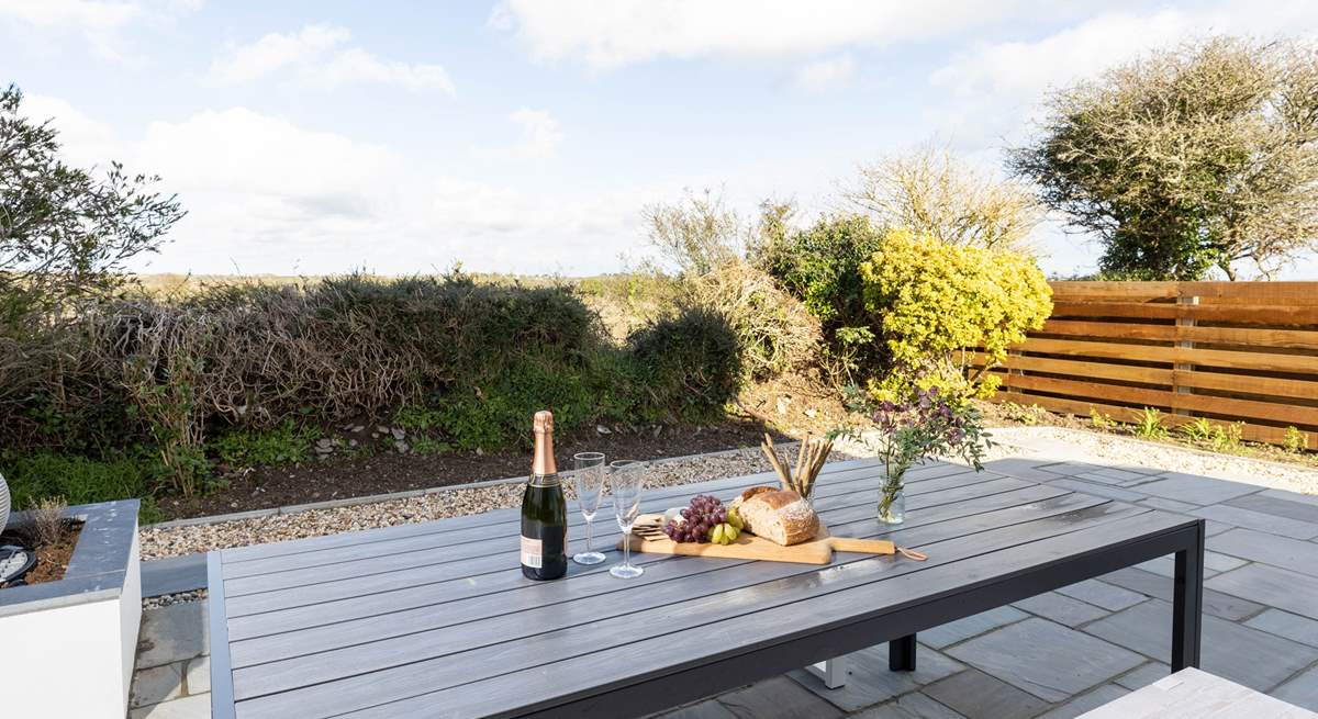 The delightful enclosed patio overlooks surrounding fields towards the sea. The perfect backdrop for al fresco dining.