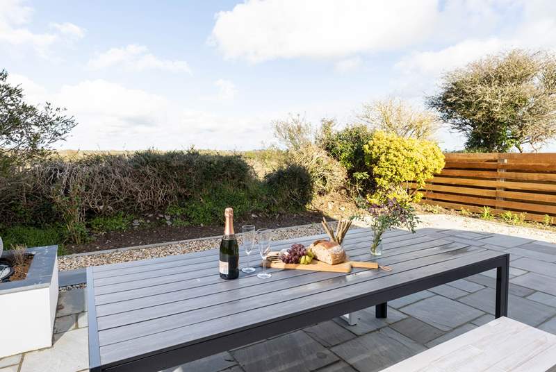 The delightful enclosed patio overlooks surrounding fields towards the sea. The perfect backdrop for al fresco dining.