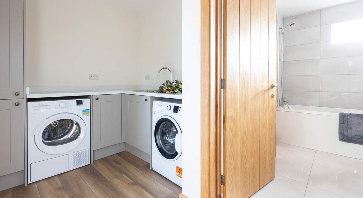 A handy utility-room is home to a washing machine and tumble-drier.