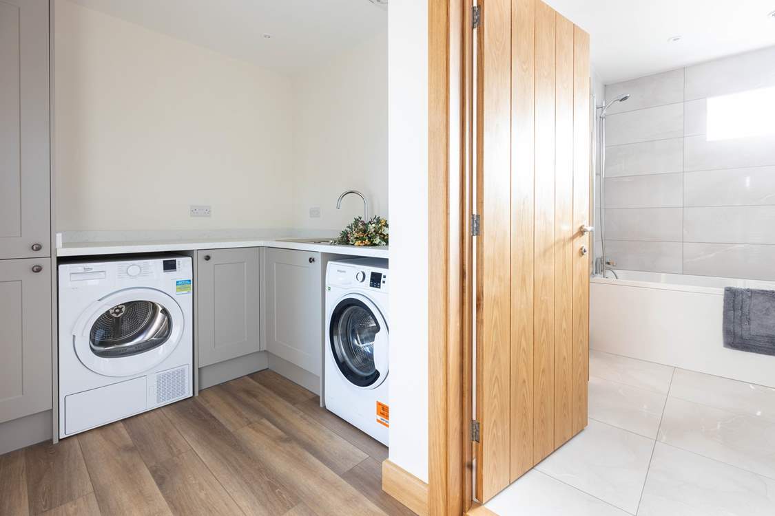 A handy utility-room is home to a washing machine and tumble-drier.