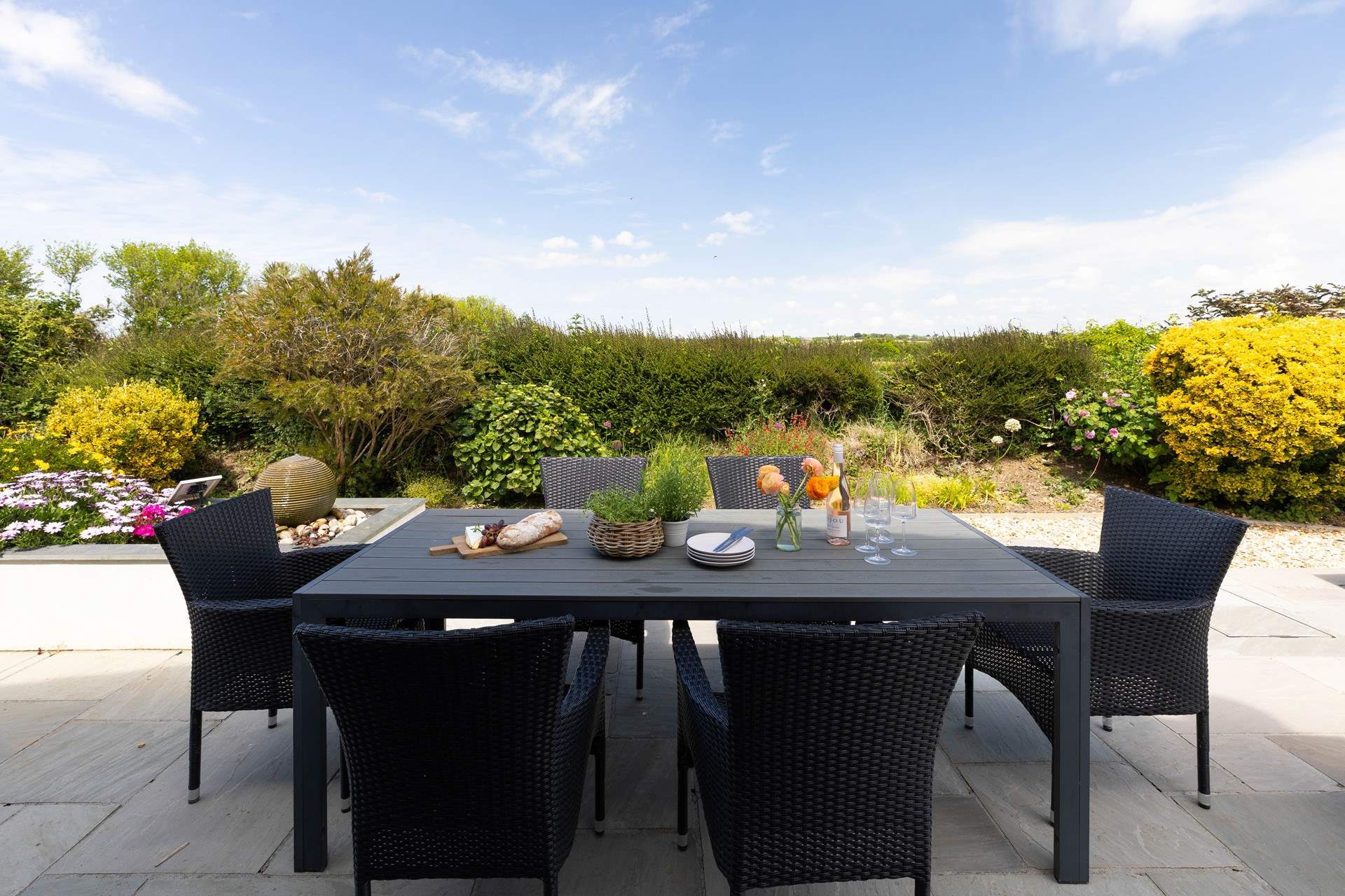 The delightful enclosed patio overlooks surrounding fields towards the sea. The perfect backdrop for al fresco dining.