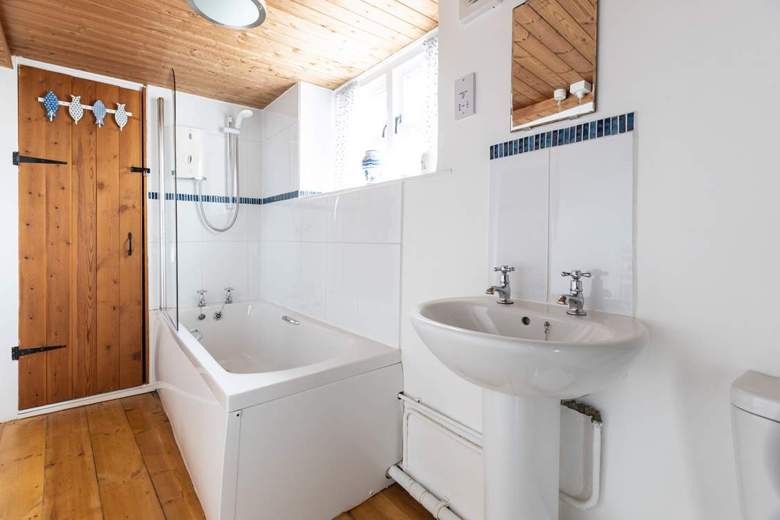 The family bathroom has a bath with shower over.