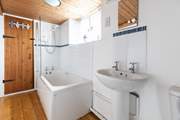 The family bathroom has a bath with shower over.
