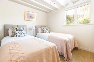 The pretty twin bedroom sits at the back of the cottage.