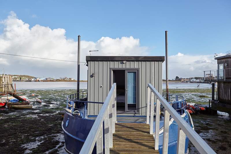 A walkway leads from land to Newclose Houseboat with the patio doors leading to bedroom 1. The entrance can be found on the right.