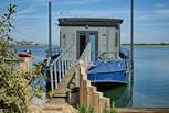 A walkway leads from land to Newclose Houseboat with the patio doors leading to bedroom 1. The entrance can be found on the right.